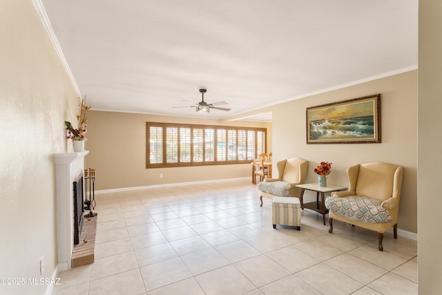 living area with a fireplace with raised hearth, light tile patterned floors, baseboards, and crown molding