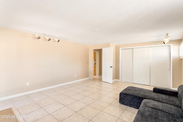 unfurnished living room featuring light tile patterned floors and baseboards