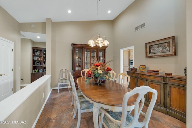 dining area with visible vents, baseboards, recessed lighting, an inviting chandelier, and a towering ceiling