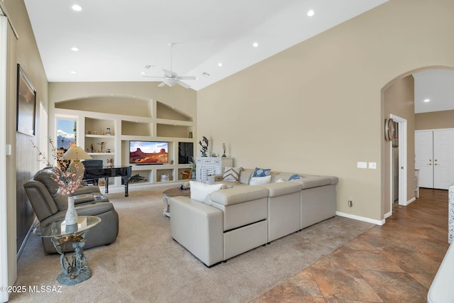 carpeted living area with built in shelves, high vaulted ceiling, recessed lighting, arched walkways, and baseboards