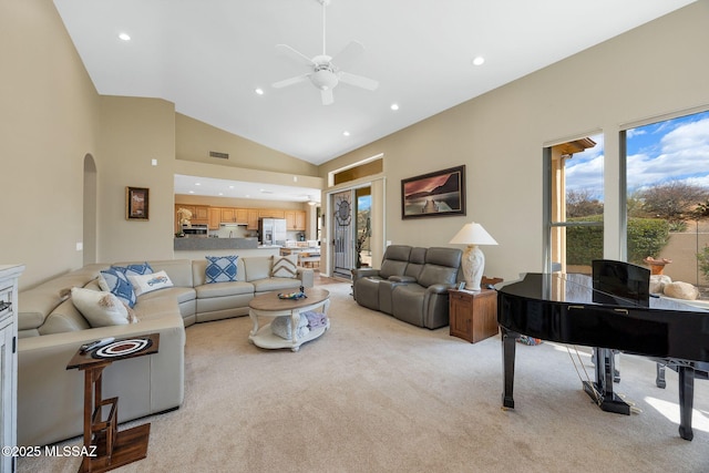 living area featuring visible vents, light colored carpet, recessed lighting, arched walkways, and high vaulted ceiling