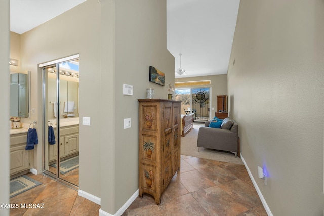 hallway with a high ceiling and baseboards