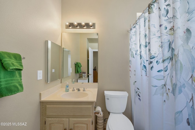 bathroom with toilet, vanity, and a shower with shower curtain