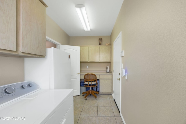 clothes washing area featuring light tile patterned floors, baseboards, cabinet space, and washer / dryer