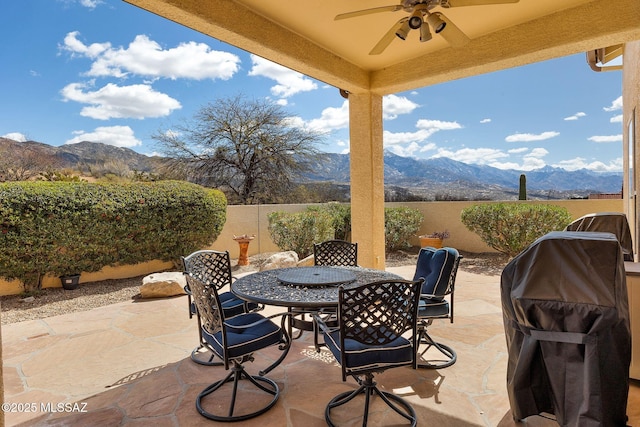 view of patio with outdoor dining space, a fenced backyard, a mountain view, and ceiling fan