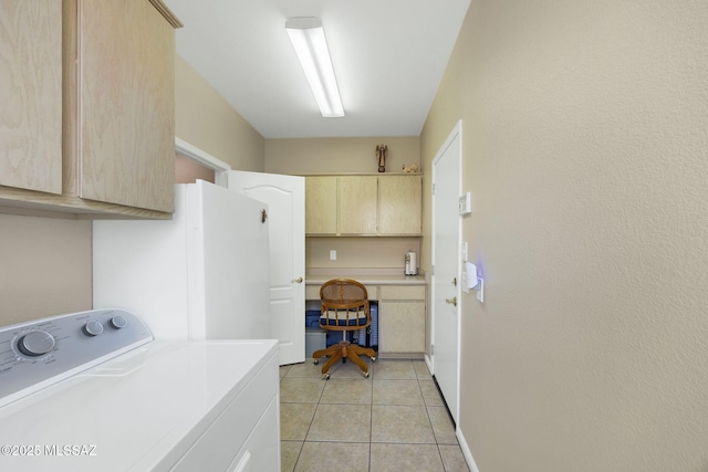 washroom featuring washer / dryer, light tile patterned floors, and cabinet space