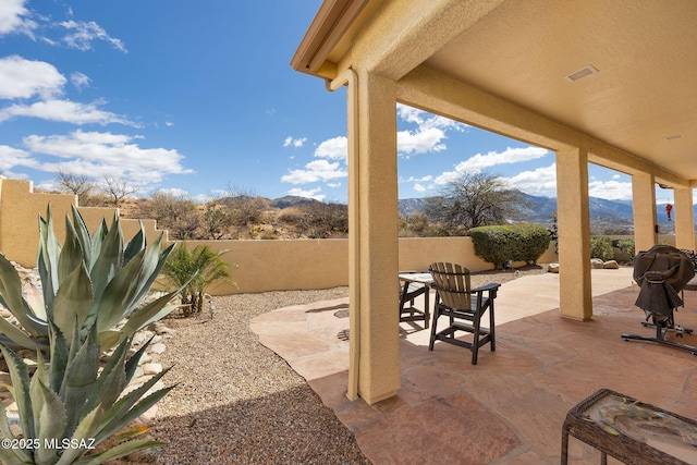 view of patio featuring a mountain view and a fenced backyard