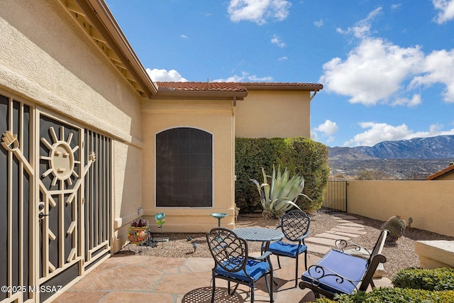 view of patio with fence and a mountain view