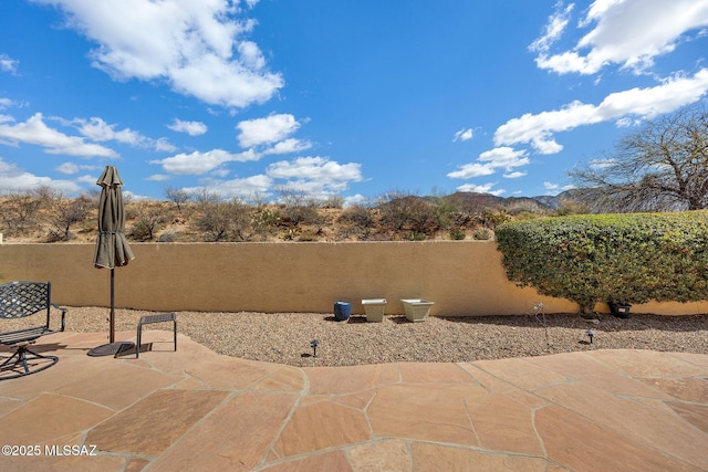 view of patio / terrace featuring a mountain view and fence