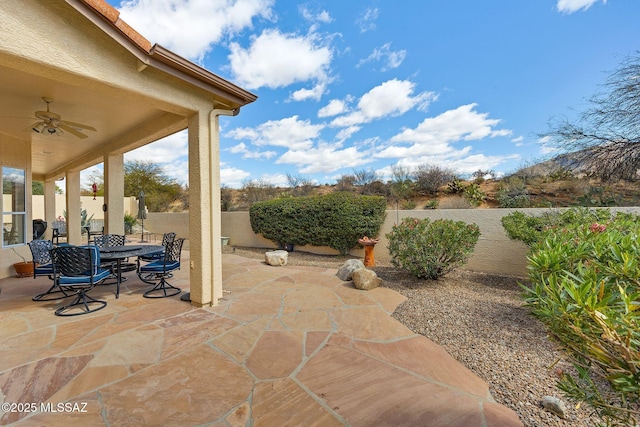 view of patio featuring a ceiling fan, outdoor dining space, and a fenced backyard