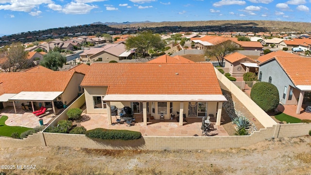 back of house featuring a fenced backyard, a residential view, and a patio