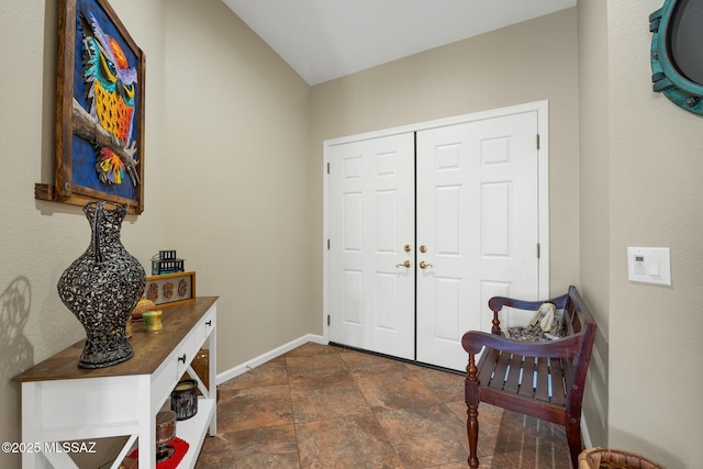 foyer entrance featuring stone finish flooring and baseboards