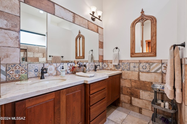 bathroom featuring double vanity, a sink, and tile walls