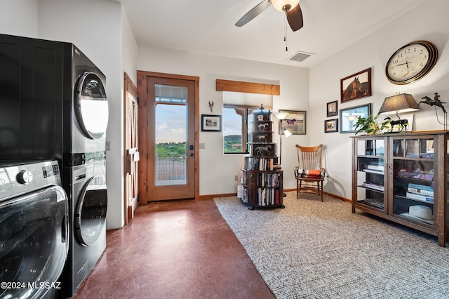 laundry area featuring stacked washer / dryer, laundry area, visible vents, and baseboards