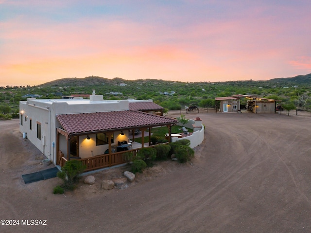 exterior space with a mountain view, a garage, a tile roof, driveway, and stucco siding