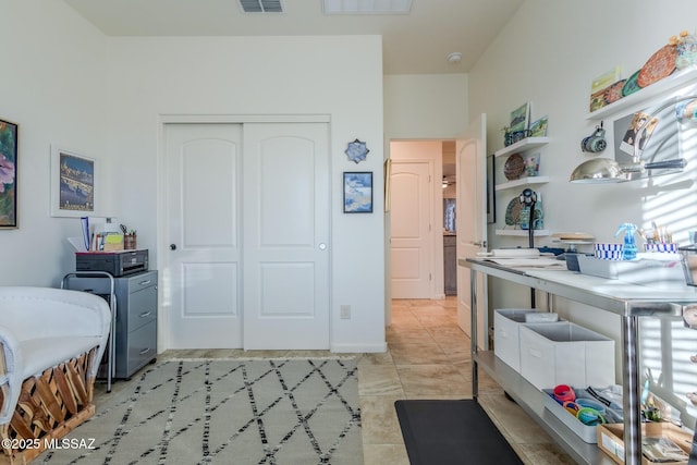 bedroom featuring a closet, visible vents, and light tile patterned floors