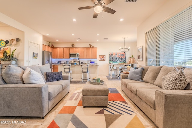 living room with recessed lighting, visible vents, light tile patterned flooring, and ceiling fan with notable chandelier