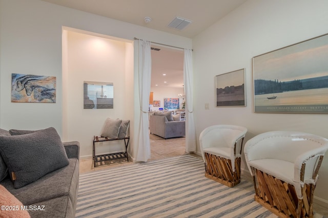 sitting room featuring light carpet, baseboards, and visible vents