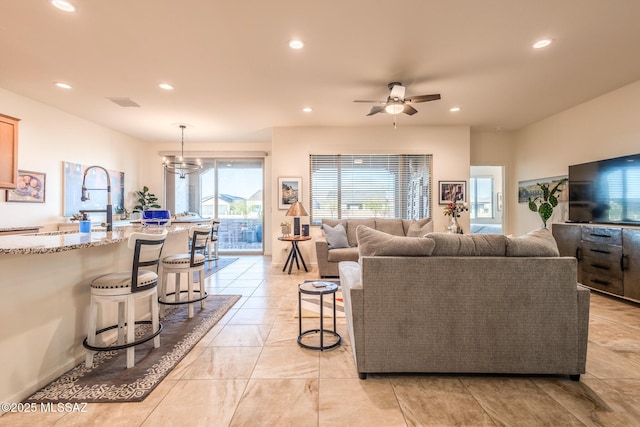 living room featuring visible vents, ceiling fan with notable chandelier, and recessed lighting