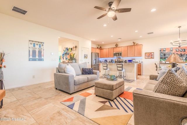 living room with recessed lighting, visible vents, baseboards, and ceiling fan with notable chandelier