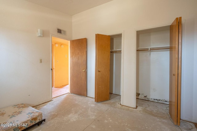 bedroom featuring two closets and visible vents