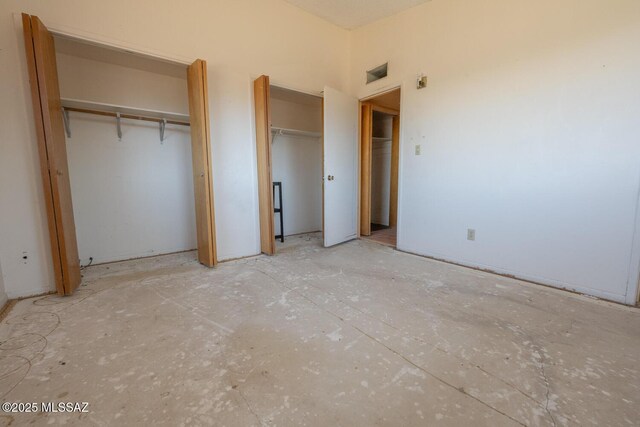 unfurnished bedroom featuring multiple closets