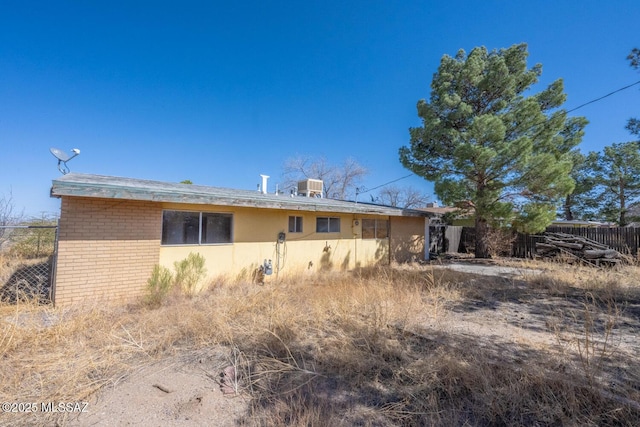 exterior space featuring brick siding and fence