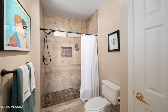 full bath featuring toilet and tiled shower