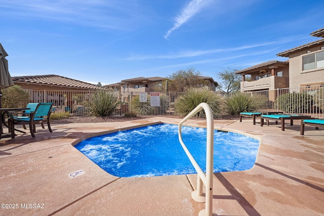 view of swimming pool featuring a patio area and fence