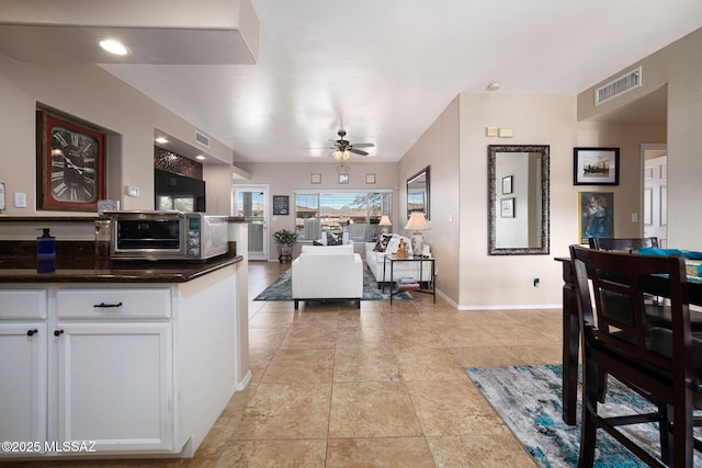 kitchen featuring visible vents, white cabinetry, a toaster, baseboards, and ceiling fan