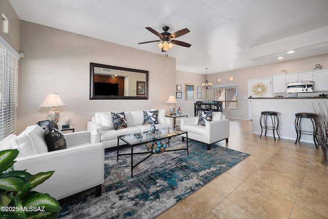 living room featuring light tile patterned floors and ceiling fan with notable chandelier