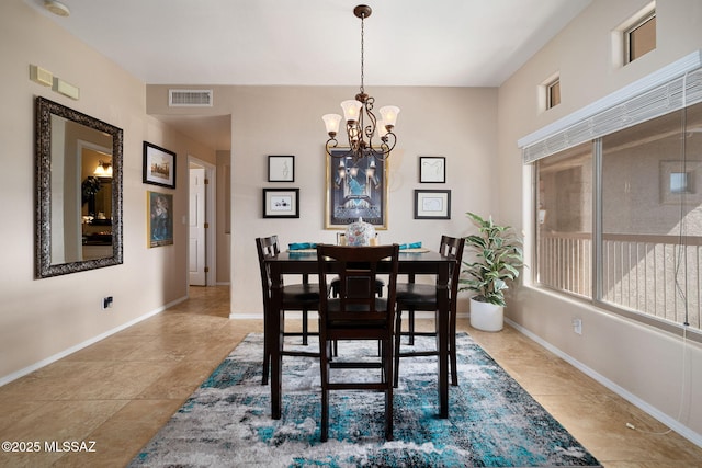 dining space featuring baseboards, visible vents, and a chandelier