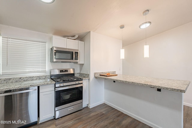 kitchen with baseboards, dark wood finished floors, a peninsula, stainless steel appliances, and white cabinetry