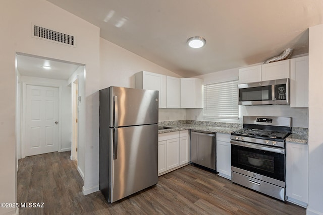 kitchen featuring white cabinets, visible vents, stainless steel appliances, and dark wood finished floors