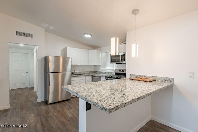 kitchen with lofted ceiling, visible vents, appliances with stainless steel finishes, a sink, and a peninsula