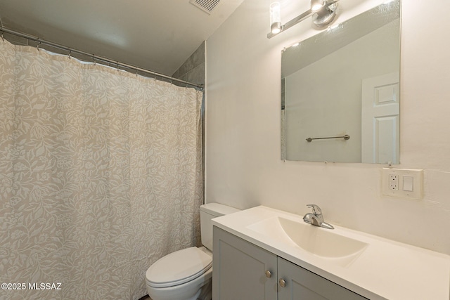 bathroom with toilet, vanity, and visible vents