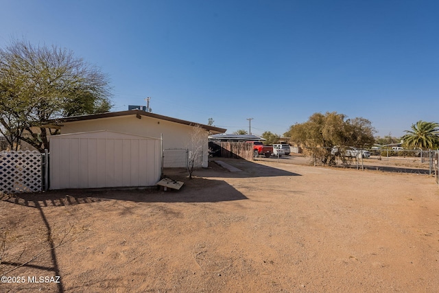 view of home's exterior featuring a storage shed, an outdoor structure, and fence