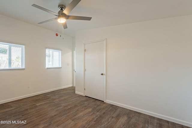 unfurnished bedroom with dark wood-type flooring, baseboards, and a ceiling fan