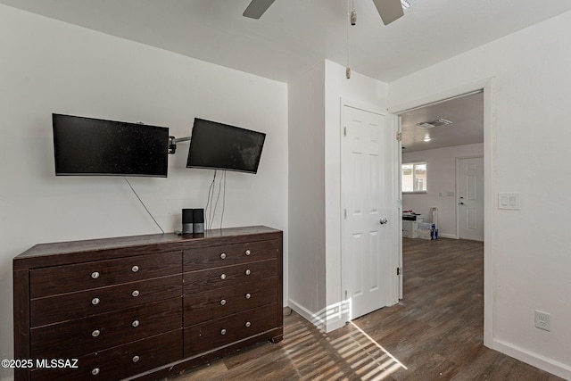 unfurnished bedroom with ceiling fan, dark wood-style flooring, visible vents, and baseboards