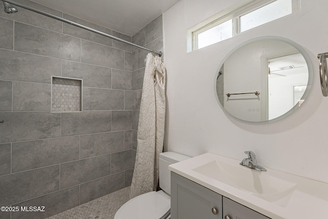 full bath with toilet, a tile shower, and vanity