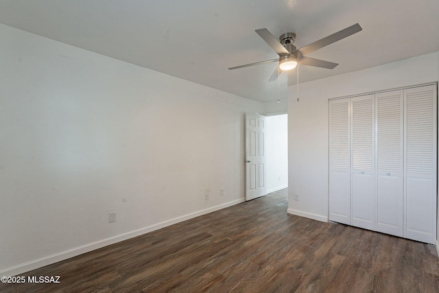 unfurnished bedroom featuring a closet, dark wood-style flooring, ceiling fan, and baseboards