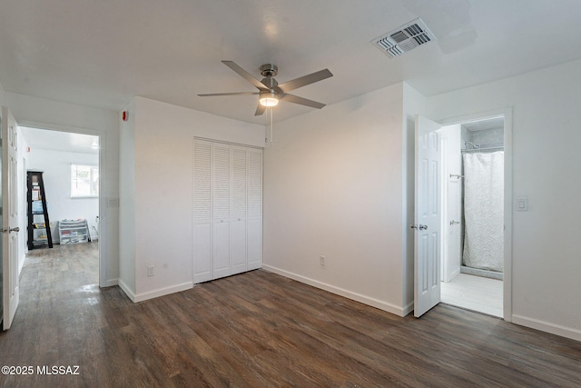 unfurnished bedroom featuring baseboards, a closet, visible vents, and wood finished floors