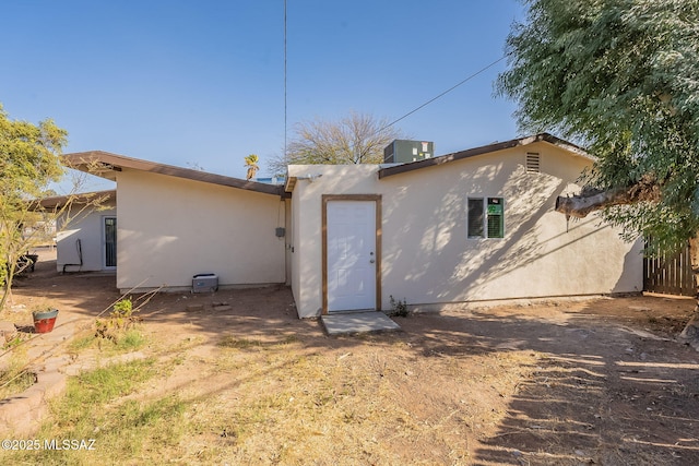 back of property with central AC and stucco siding