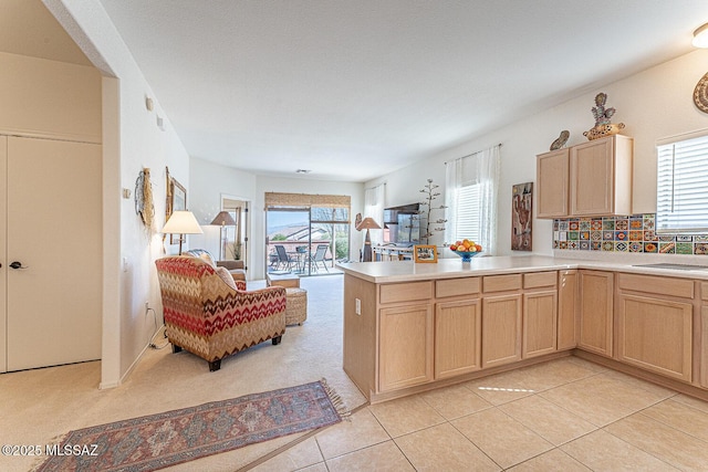 kitchen featuring light countertops, plenty of natural light, light brown cabinets, and a sink