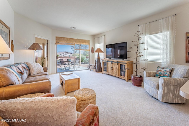 carpeted living room featuring visible vents and a healthy amount of sunlight