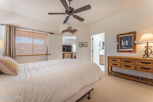 bedroom with light carpet, ensuite bath, and a ceiling fan