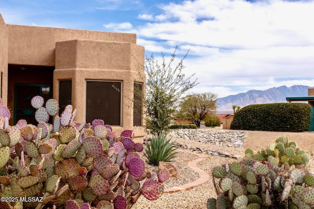 view of property exterior with a mountain view and stucco siding