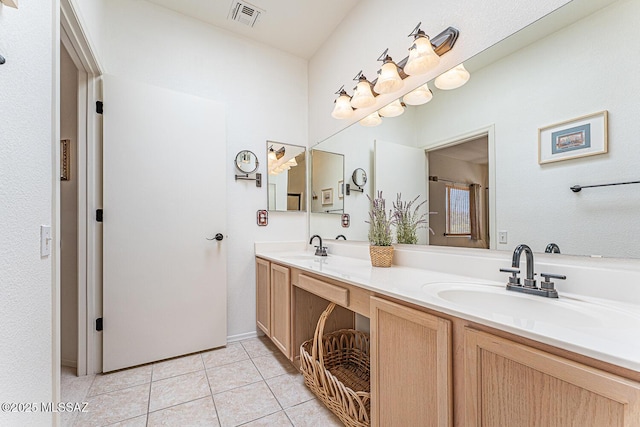 bathroom featuring a sink, visible vents, double vanity, and tile patterned flooring