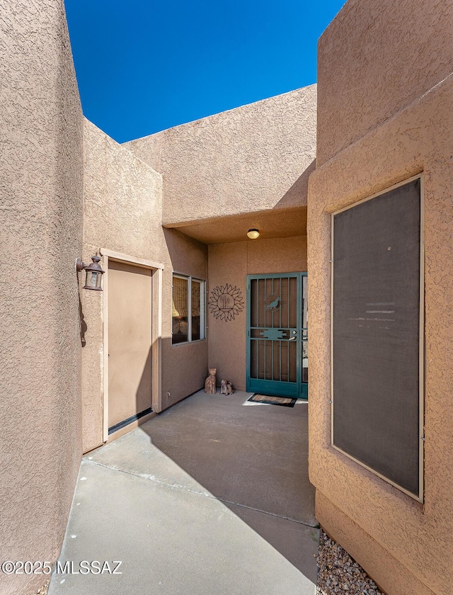 doorway to property featuring a patio and stucco siding