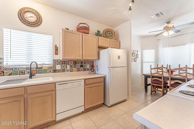 kitchen with visible vents, light brown cabinets, a sink, white appliances, and light tile patterned floors